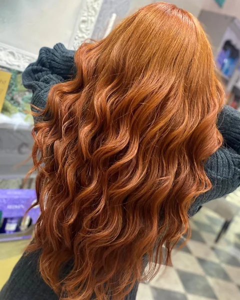 Rich copper hair styled in loose waves at RAGE
