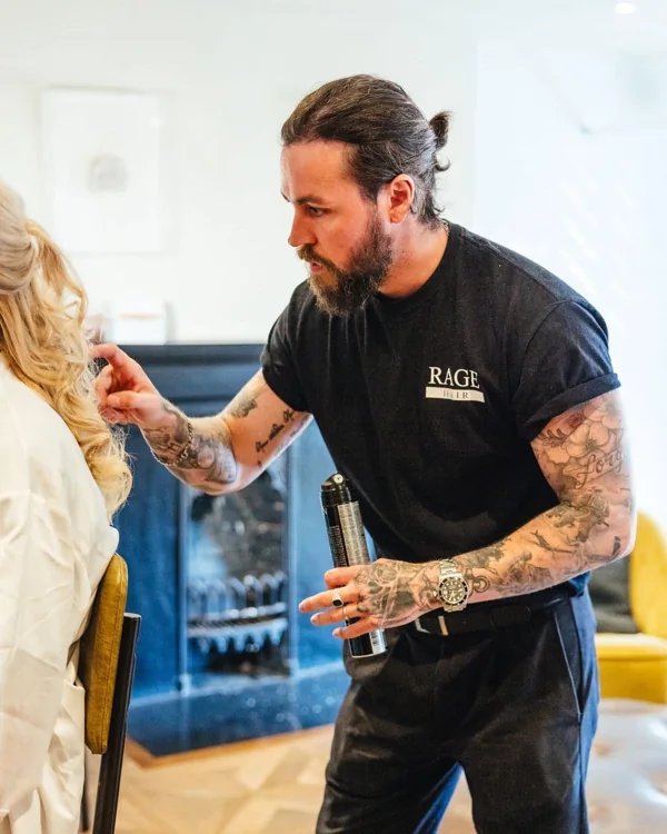 Ryan, owner of RAGE Hair, styling a client’s blonde hair