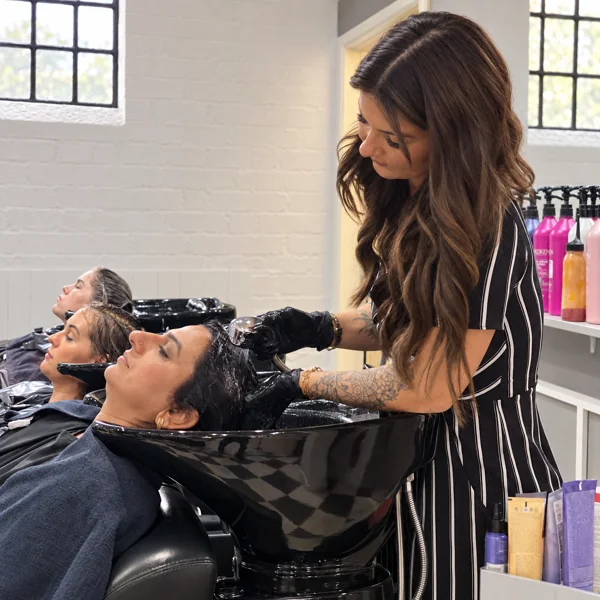 A RAGE stylist caring for a client’s hair at the wash basin